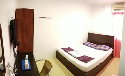 a small bedroom with a small bed and a table at Hotel Tanjong in Tanjung Malim