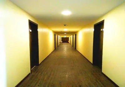 an empty hallway with a long aisle in a building at Angsoka Hotel in Teluk Intan