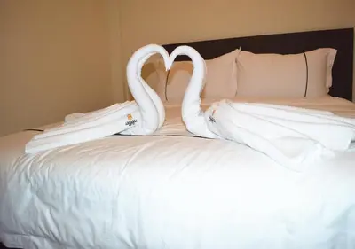two swansuitsrendered to look like they are kissing on a bed at Angsoka Hotel in Teluk Intan
