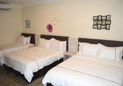 a hotel room with two beds with white sheets at Angsoka Hotel in Teluk Intan