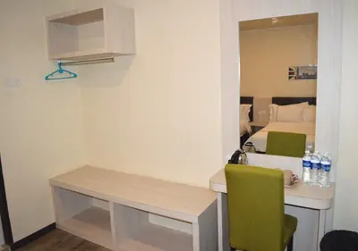 a small room with a desk and a bed at Angsoka Hotel in Teluk Intan