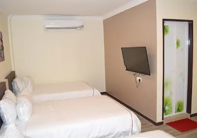 a room with two beds and a flat screen tv at Angsoka Hotel in Teluk Intan