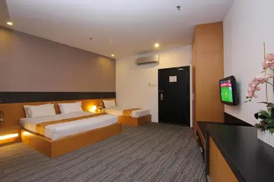 a hotel room with a bed and a flat screen tv at Flemington Hotel in Taiping