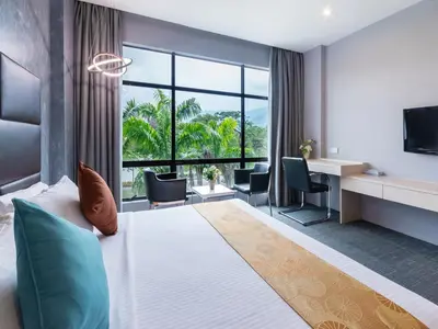 a hotel room with a large bed and a desk at Flemington Hotel in Taiping