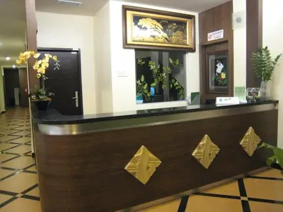 a reception desk in a hotel lobby with gold arrows at Tropicana Inn in Sitiawan
