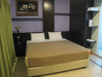 a bedroom with a large bed in a room at Tropicana Inn in Sitiawan