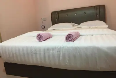a bed with two pink pillows on top of it at Anderson Hotel in Ipoh
