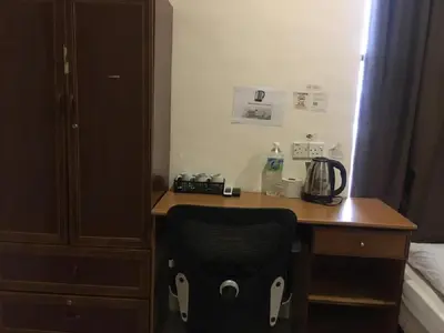 a desk with a black chair in a hotel room at Anderson Hotel in Ipoh