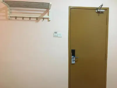 a brown door is next to a wall at Anderson Hotel in Ipoh