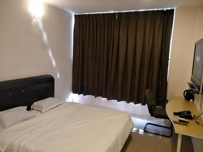 a bedroom with a bed and a desk and a window at Anderson Hotel in Ipoh