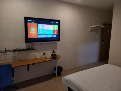 a room with a tv on a wall with a bed at Anderson Hotel in Ipoh
