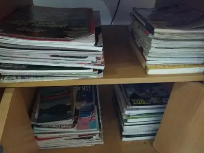 a shelf with a stack of magazines and books at Homestay Amsyarah in Seri Iskandar
