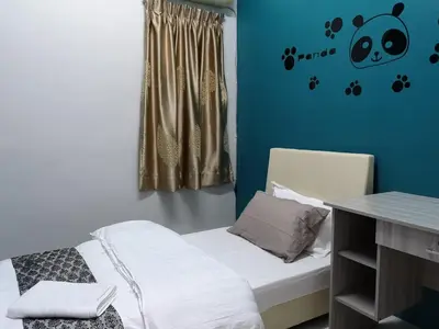 a small room with a bed and a table at Kelly Cozy cottage in Kampar