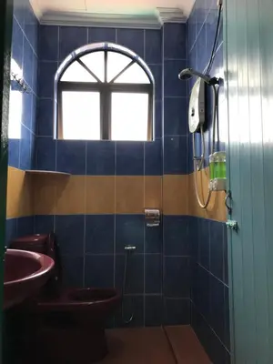 a bathroom with a toilet and a sink and a window at Kangsar Hotel in Kuala Kangsar