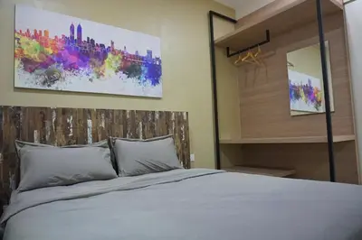 a bedroom with a bed and a painting on the wall at PM Octagon Ipoh Suites & Apartment 2 in Ipoh