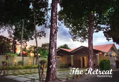 a house with trees in front of it at The Retreat Homestay in Tanjung Malim