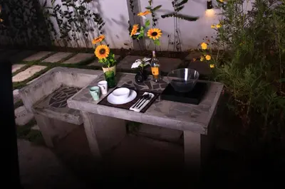 a stone table with a bowl and flowers on it at The Retreat Homestay in Tanjung Malim