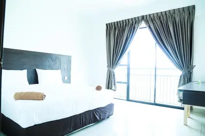 a bedroom with a large bed and a balcony at Marina Heights Resort in Lumut