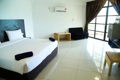 a bedroom with a bed and a couch and a chair at Marina Heights Resort in Lumut