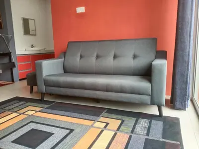 a gray couch in a room with an orange wall at NAUFAL MUSLIM'S HOMESTAY in Cameron Highlands