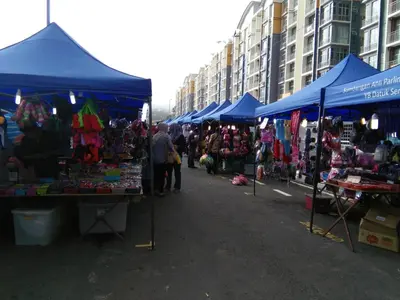 a market with blue umbrellas and people standing around at NAUFAL MUSLIM'S HOMESTAY in Cameron Highlands