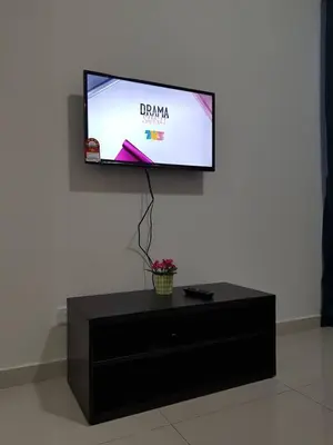 a flat screen tv sitting on top of a black entertainment center at MS Vacation Home (Muslim Homestay) in Cameron Highlands