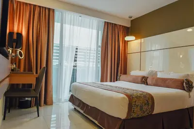 a hotel room with a large bed and a window at Hotel Sfera in Lumut