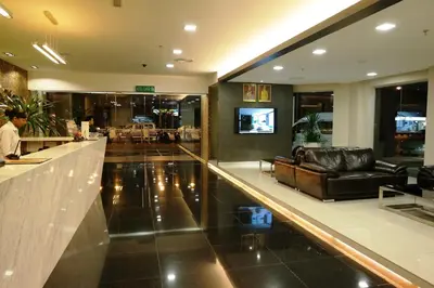a lobby with a leather couch and a bar at Hotel Sfera in Lumut