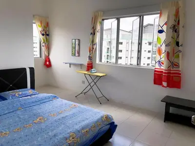 a bedroom with a bed and a table and windows at CH Homestay in Cameron Highlands