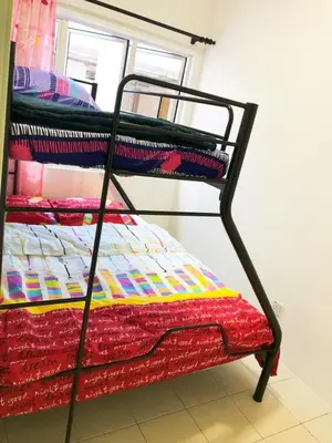 a black bunk bed with a colorful quilt on it at CH Homestay in Cameron Highlands