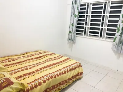 a bed sitting in a room with a window at CH Homestay in Cameron Highlands