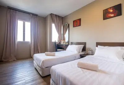 a hotel room with two beds with white sheets at Chariton Hotel Butterworth in Butterworth
