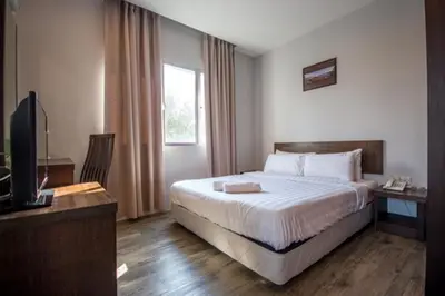 a hotel room with a bed and a television at Chariton Hotel Butterworth in Butterworth