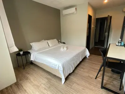 a bedroom with a white bed and a table at Chariton Hotel Butterworth in Butterworth