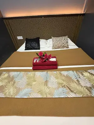 a bedroom with two beds with flowers and a red box at Weng Kong Hotel in Slim River