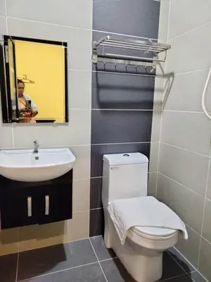 a bathroom with a white toilet and a sink at Weng Kong Hotel in Slim River
