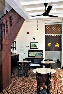 a restaurant with tables and chairs and a piano at Nam Keng Hotel Penang in George Town