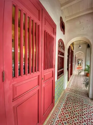 a red door in a hallway with a tile floor at Nam Keng Hotel Penang in George Town
