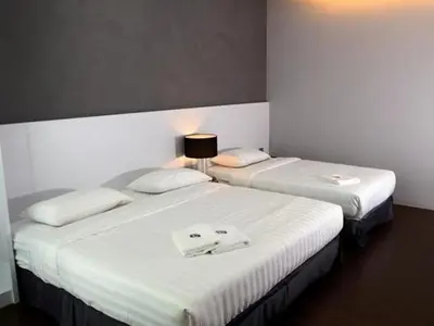 two beds in a hotel room with towels on them at Chariton Hotel Ipoh in Ipoh