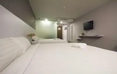 a large white bed in a room with a tv at Chariton Hotel Ipoh in Ipoh