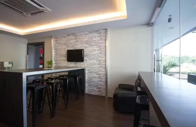 a bar with stools and a tv on a brick wall at Chariton Hotel Ipoh in Ipoh