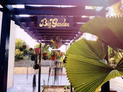 a sign for a flower shop with a large plant at Big Garden Homestay in Pantai Remis