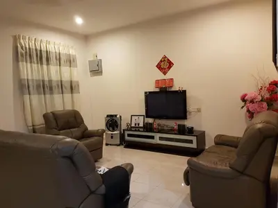 a living room with two chairs and a flat screen tv at Big Garden Homestay in Pantai Remis