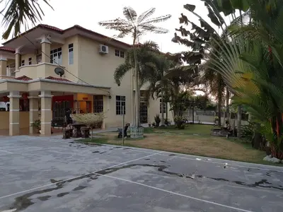 a building with palm trees in front of it at Big Garden Homestay in Pantai Remis