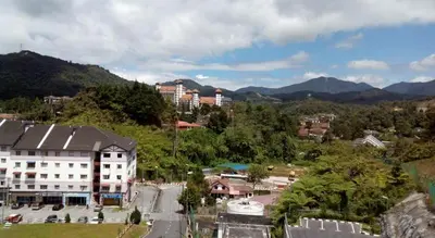 a town with a building and mountains in the background at Azizi&Yati Muslim Homestay Cameron Highlands in Cameron Highlands