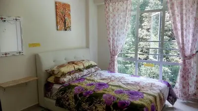 a bedroom with a bed in front of a window at Azizi&Yati Muslim Homestay Cameron Highlands in Cameron Highlands