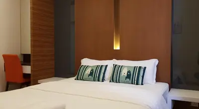 a bedroom with a bed with two pillows on it at Peony Square Residences in Cameron Highlands