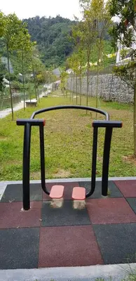 a park bench with two orange seats on a playground at Peony Square Residences in Cameron Highlands