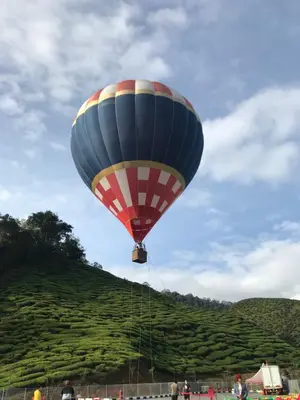 a hot air balloon is flying over a hill at Peony Square Residences in Cameron Highlands