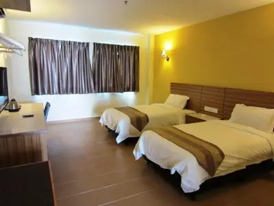 a hotel room with two beds and a window at Grand Court Hotel in Teluk Intan